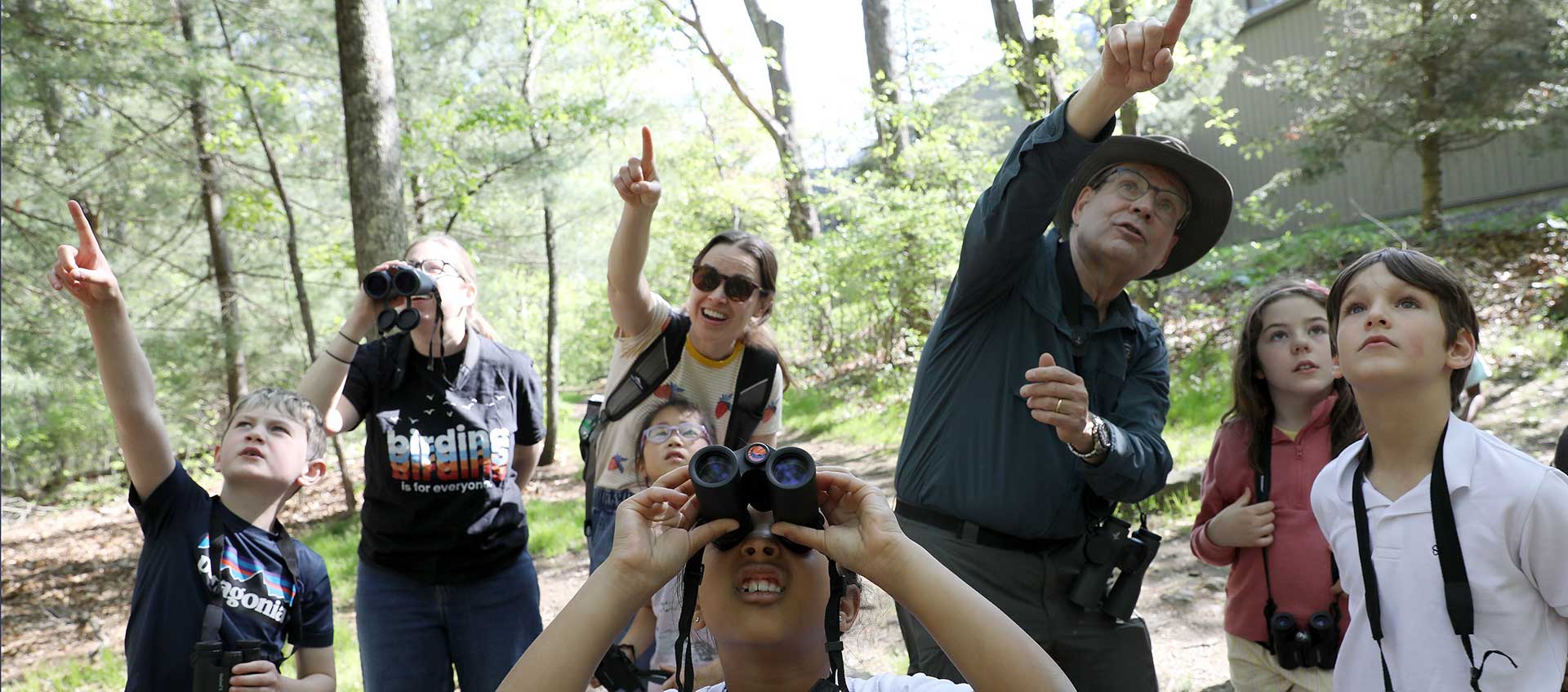 Second graders enjoy a birding adventure in the woods surrounding campus