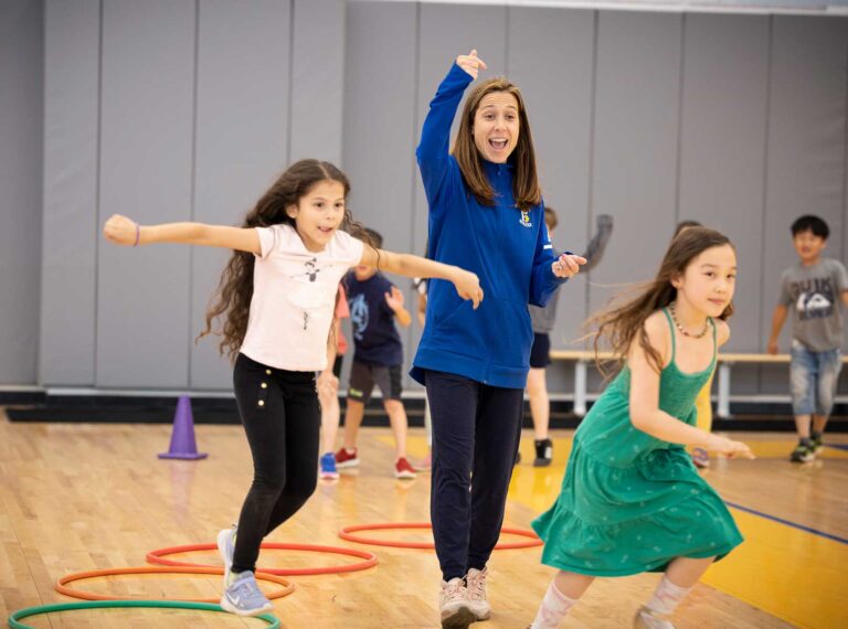 Students run in the gym during PE class