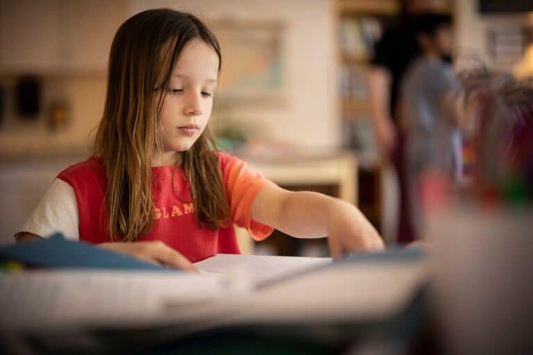 A student writes at her desk