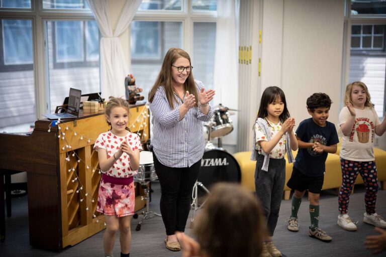 Music teacher Kassie Bettinelli and students clap together