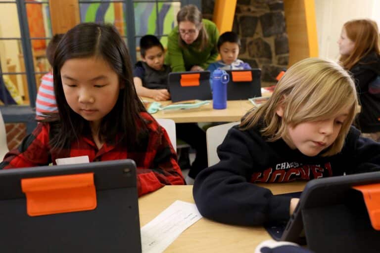 Four students with the librarian conducting online research