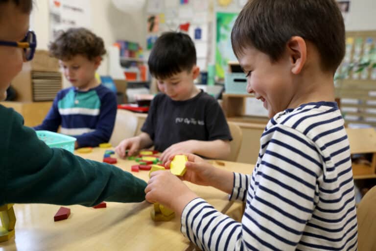 Four pre-k students work with math manipulatives