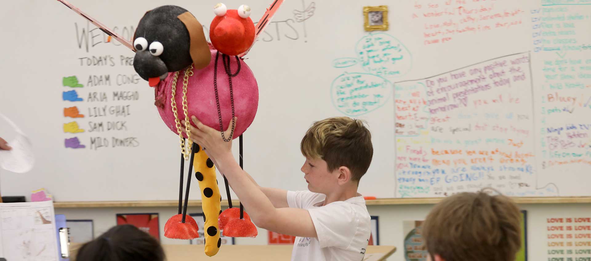 A student presents his animal sculpture to the class