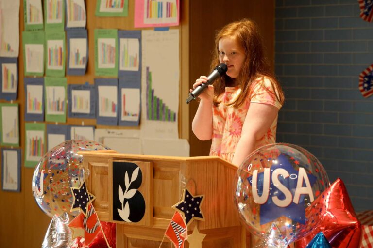 A student holds a microphone to present at the State Fair