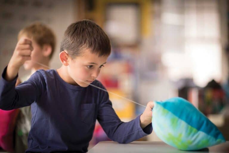 A student sews a pillow in art class